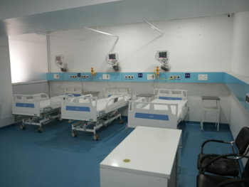 Hospital room with three beds and medical equipment